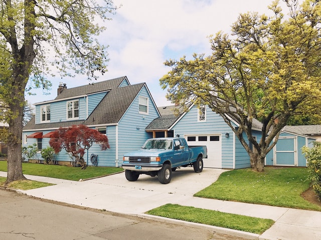 blue truck in home's driveway waiting for mobile Baytown windshield repair services from Joey's Glass